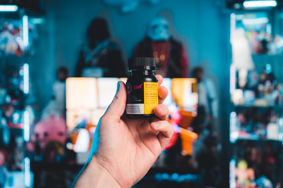 Close-up of a hand holding a medicine bottle in a colorful room with LED lights.