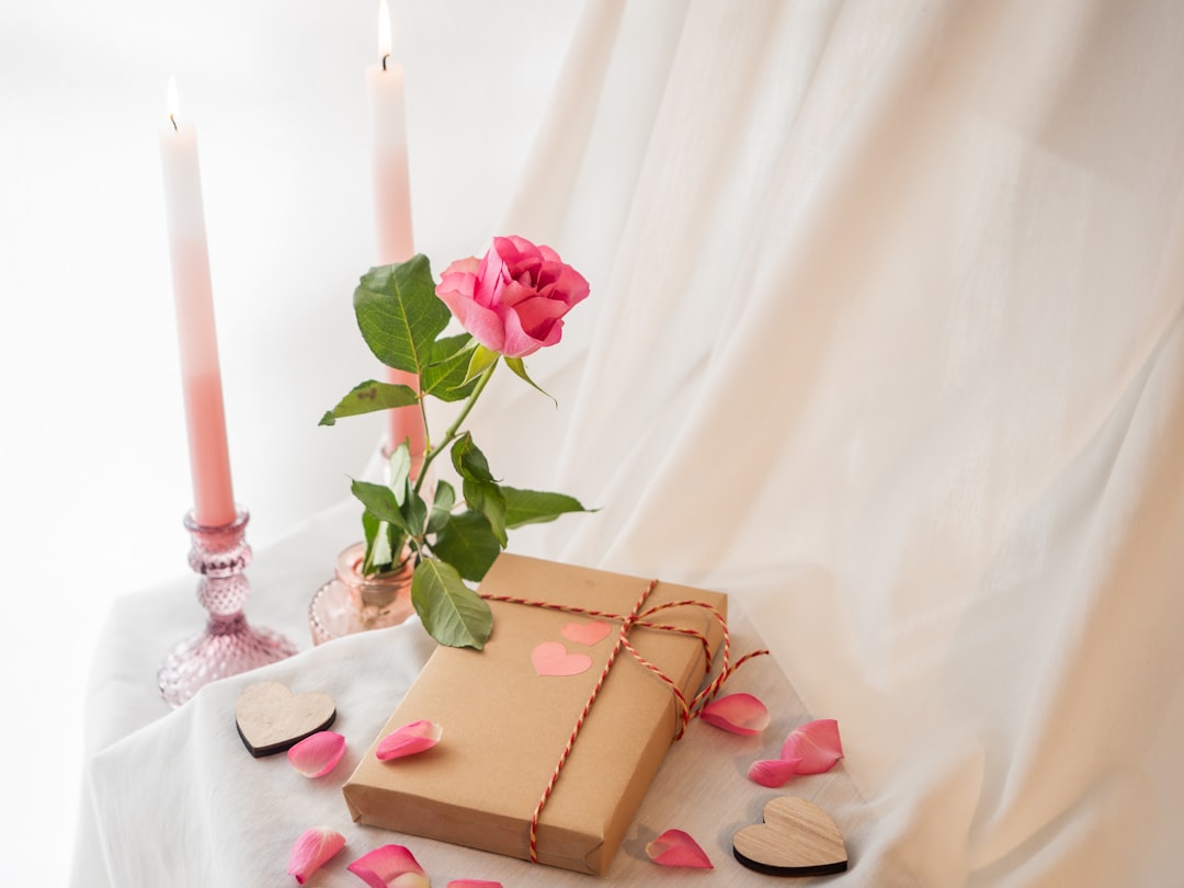 a present box with hearts and a rose on a table