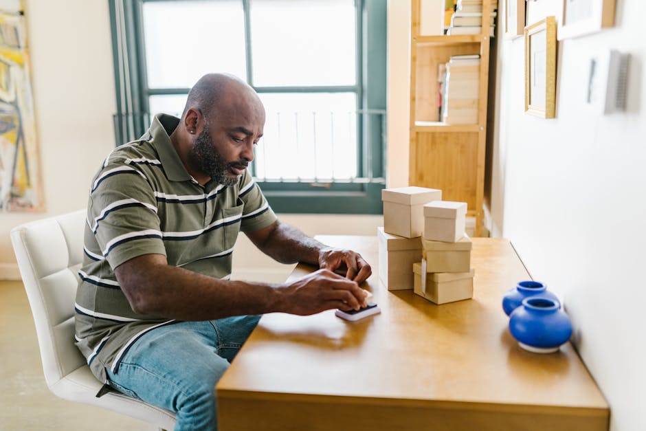 Bearded man in home office preparing packages for a small business startup.