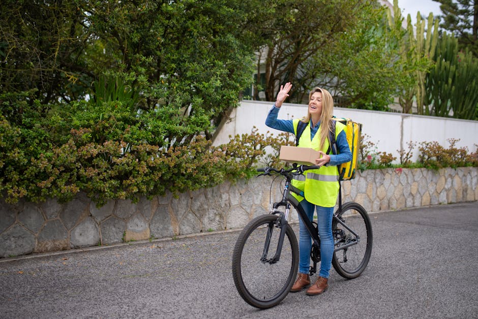 A happy courier on a bicycle delivers a package while waving, set against a vibrant outdoor backdrop.