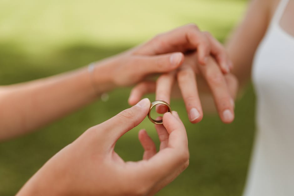 A beautiful close-up of two individuals exchanging wedding rings, symbolizing love and commitment.