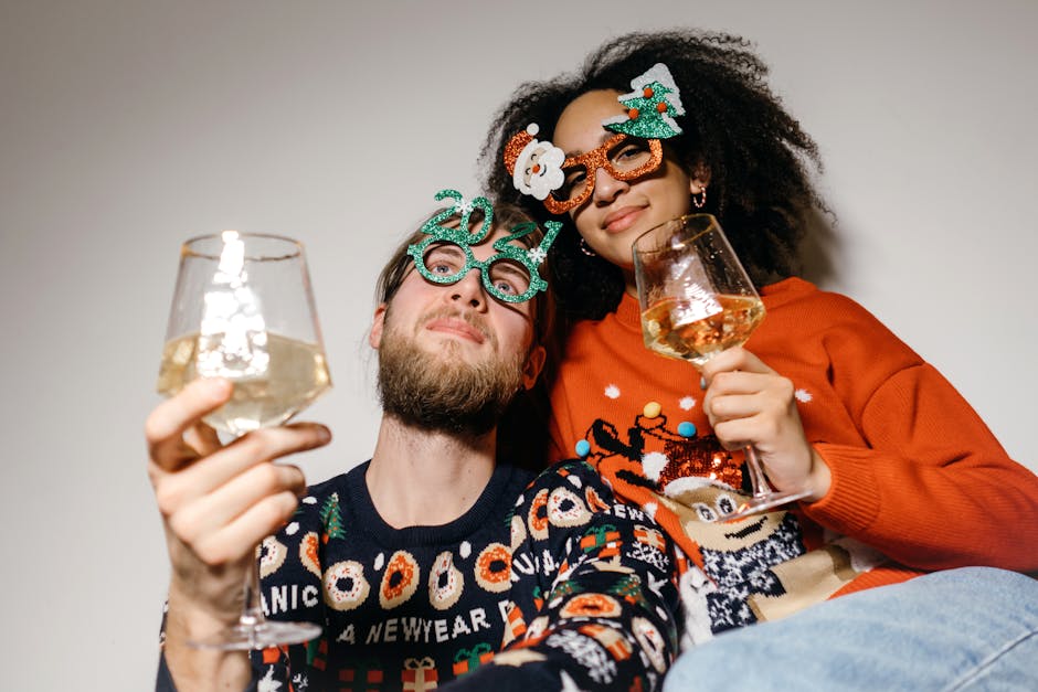 A cheerful couple celebrating the New Year with festive glasses and white wine indoors.