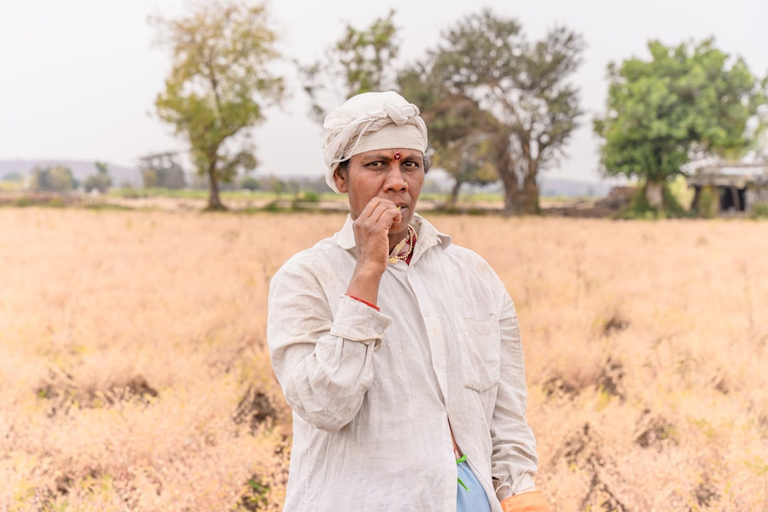 a man standing in a field holding a book