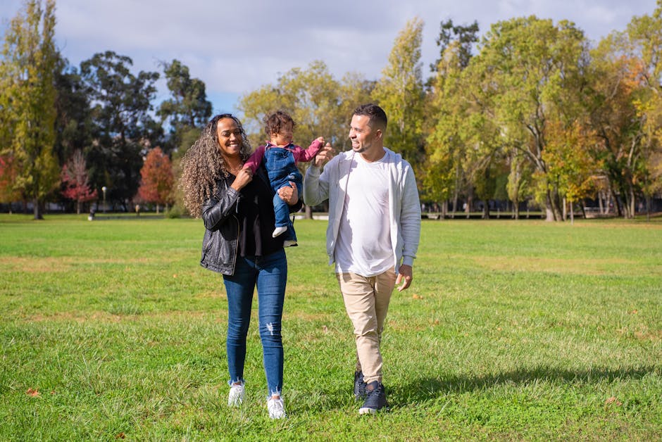 A joyful family walking in a sunny park, enjoying quality time together.
