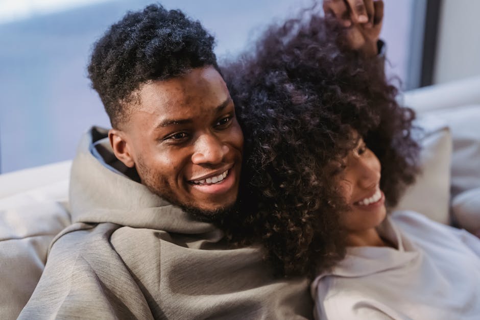 Happy couple enjoying a cozy and relaxing moment on a sofa indoors.