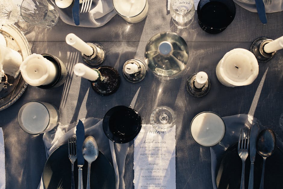 Aerial shot of a minimalist dining table set with candles and tableware.